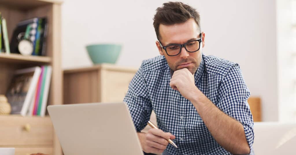 Man reviewing rental history on laptop for eviction checks.