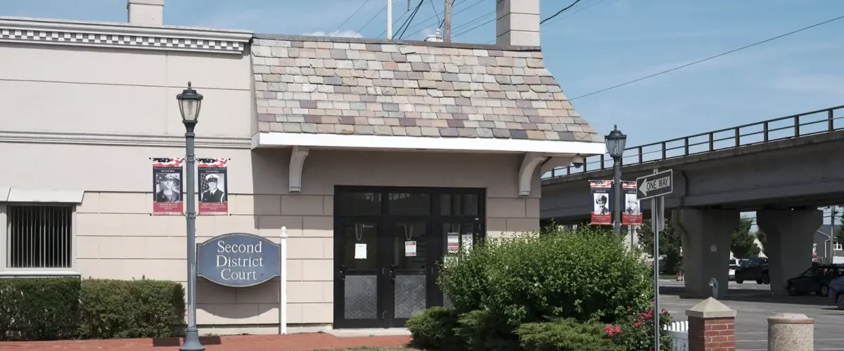 Long Island eviction court building with signage and surrounding greenery.